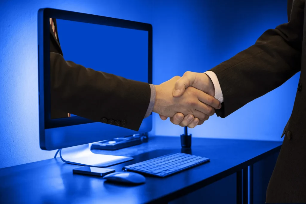 Person handshake with an arm coming out of a computer, symbolising computing trust
